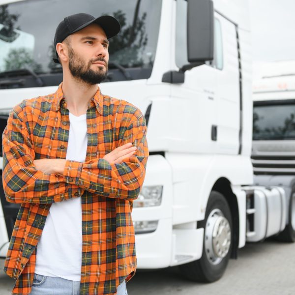 Men driver near lorry truck. Man owner truck driver near truck. Man trucker trucking owner. Transportation industry vehicles. Handsome man driver front of truck